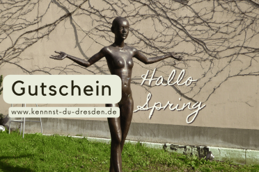 Bronzefigur mit ausgebreiteten Armen vor begrünter Hauswand in Dresden, daneben Gutschein-Hinweis für Stadtführung