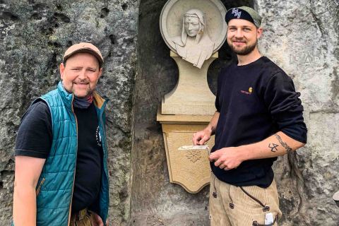 Steinbildhauer Thore Brilloff und Steinmetz Martin Richter befestigen das neue Sandsteinmedaillon in der Mariengrotte unterhalb der Festung Königstein.