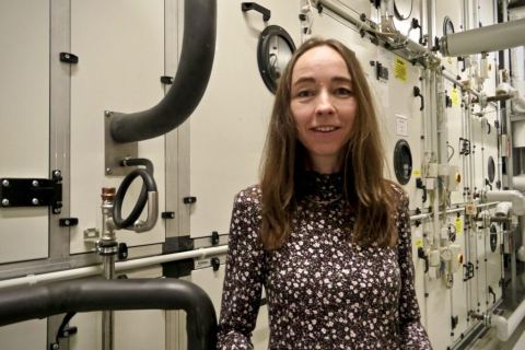 Dr. Kristin Klaudia Kaufmann steht vor einer modernen technischen Anlage im Krankenhaus Dresden-Friedrichstadt und spricht über nachhaltige Investitionen.