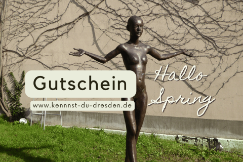 Bronzefigur mit ausgebreiteten Armen vor begrünter Hauswand in Dresden, daneben Gutschein-Hinweis für Stadtführung