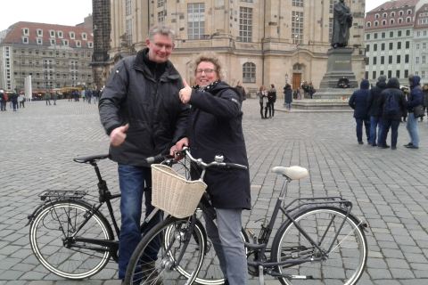 Besucher:innen einer Wintertour in Dresden, warm eingepackt, während sie einem Guide auf dem Neumarkt zuhören.
