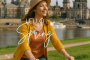 Frau mit Fahrrad am Elbufer in Dresden im Frühling, im Hintergrund die Altstadt mit der Frauenkirche – ideal für Stadtführungen mit Gutschein.